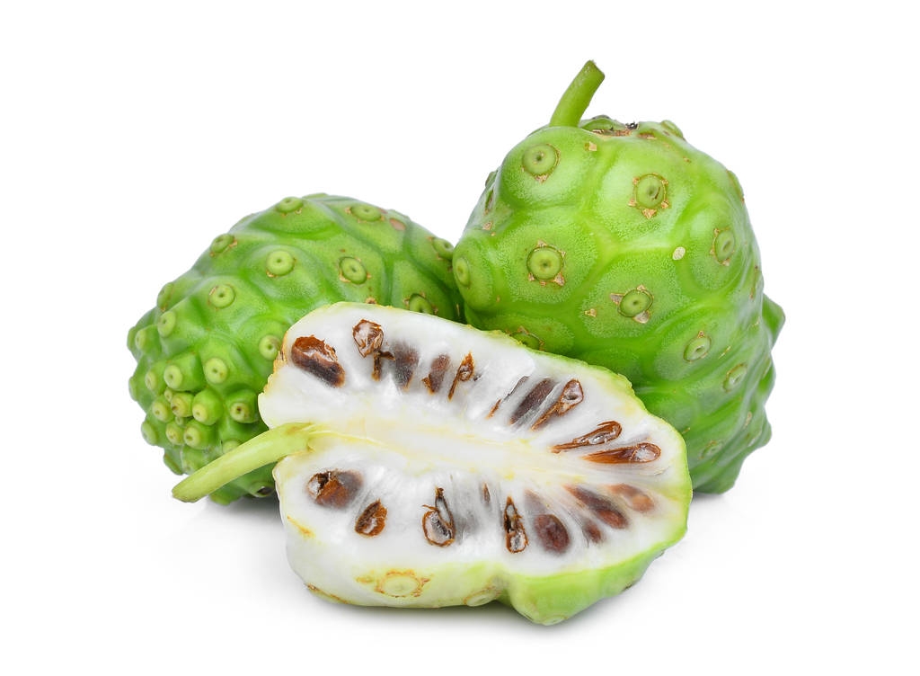 整个和一半的白色背景上孤立的诺丽果 整个和一半的白色背景上孤立的诺丽果