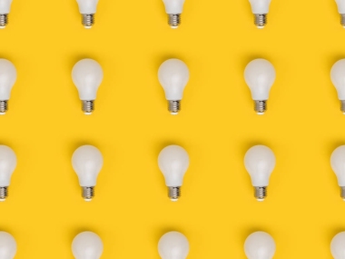 在黃色上隔離燈泡的全幀布置圖片