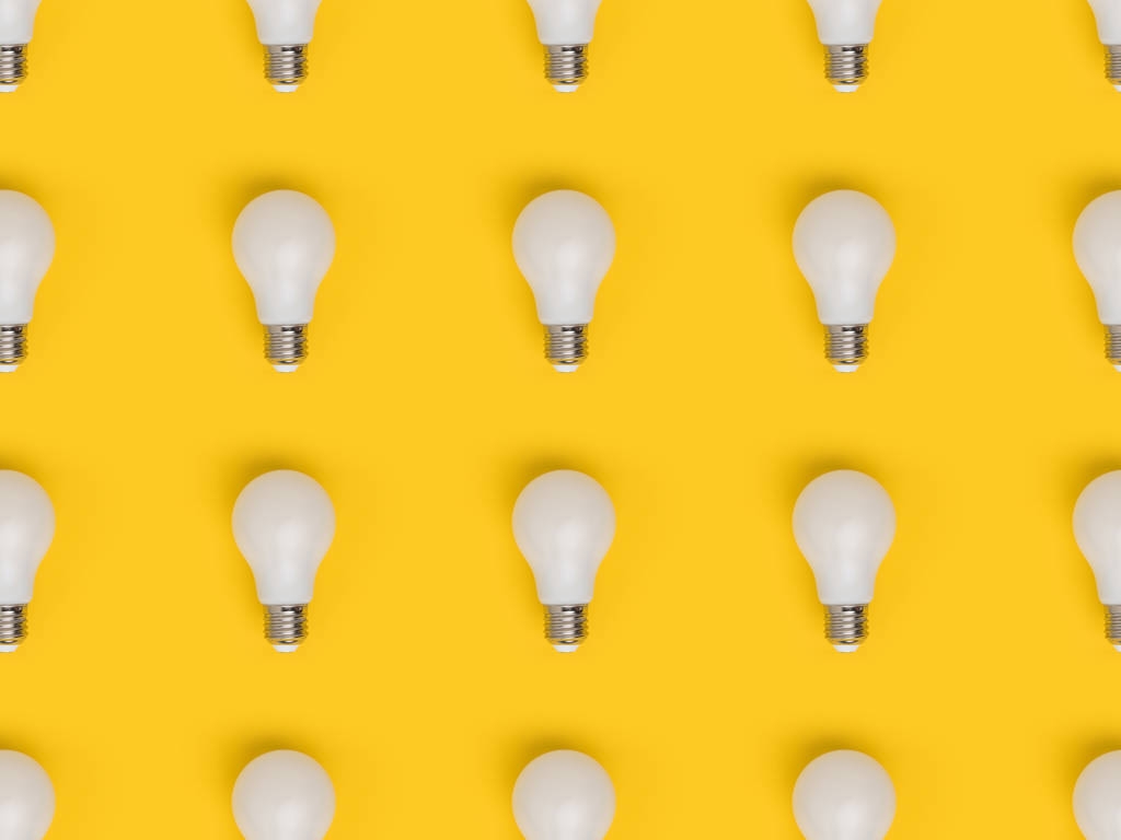 在黄色上隔离灯泡的全帧布置图片