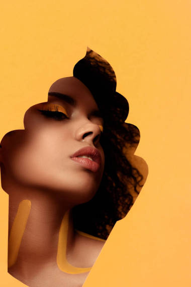 年轻感性的非洲裔美国妇女与艺术的化妆, 在头发在纸杯蛋糕框架