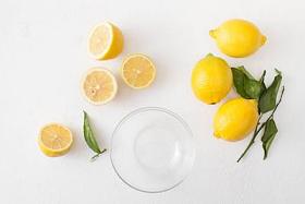 一束柠檬, 叶子和柠檬片在白色的水泥背景下