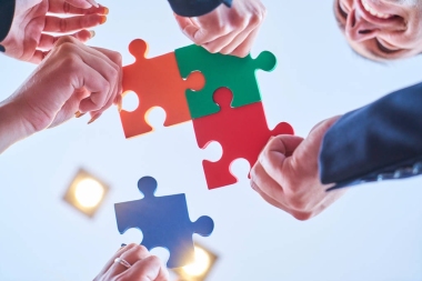 集團的業(yè)務(wù)人員組裝拼圖和代表團隊支持和幫助概念在現(xiàn)代辦公室