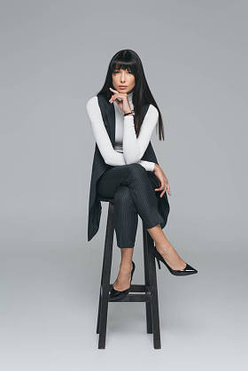 有吸引力的黑发女子休息下巴上的灰色隔离