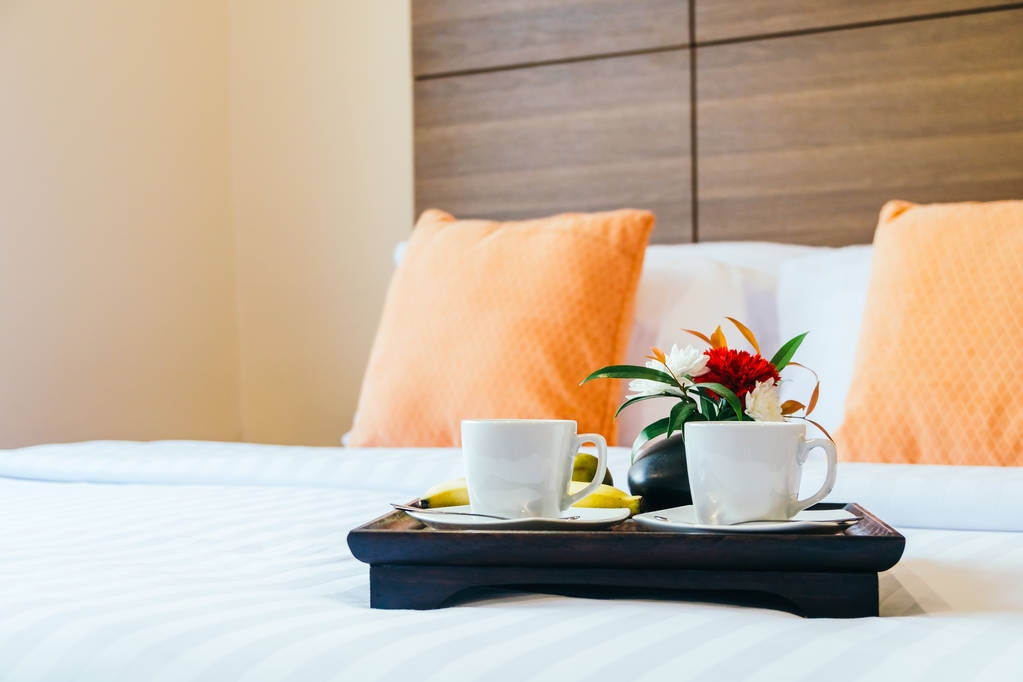 早餐咖啡在卧室内部的床上装饰