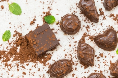 甜甜點(diǎn)與黑巧克力片斷和可可粉在白色石頭背景