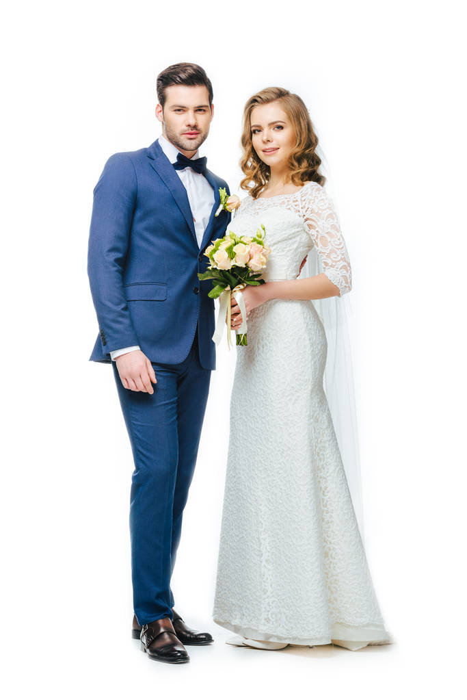 年轻的新婚夫妇看着相机隔离白色