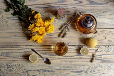 有用的草本茶與植物（西地炎卡）或希臘山茶與檸檬在杯子和黃菊花在木桌特寫