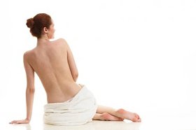 裸体女人坐在白色的毛巾图片