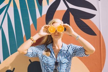 年轻快乐的女人摆着橙色反对彩色绘画