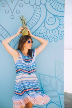 用菠萝冒充蓝色画的年轻幸福的妇女