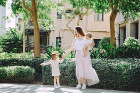 幸福美丽的母亲与她可爱的小女儿在公园休息的肖像