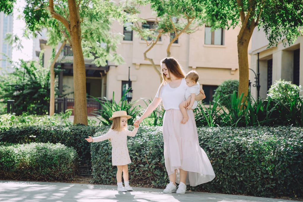 幸福美丽的母亲与她可爱的小女儿在公园休息的肖像