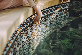 可爱的小女孩触摸喷泉的水