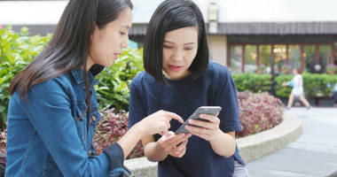 朋友在戶外使用智能手機照片