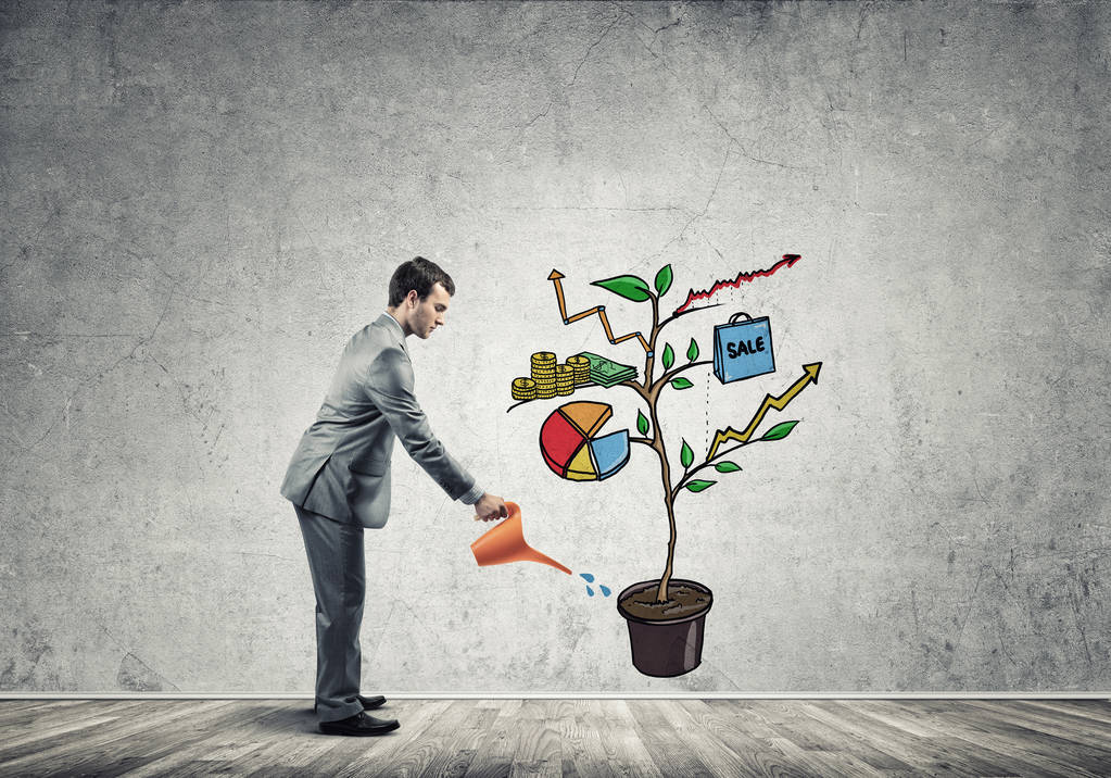 英俊的生意人浇灌画增长的概念与罐头 