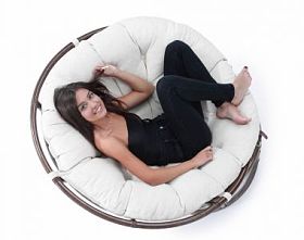 年轻女子在大舒适的扶手椅上休息