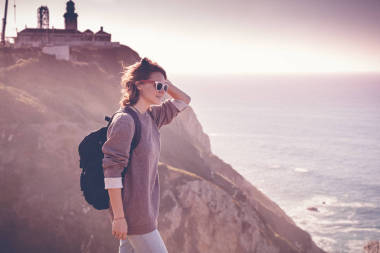 年轻美丽的妇女游人与背包, 反对 backd