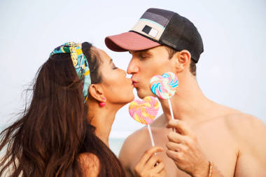 夏日的生活, 親密的戀人接吻的肖像。握在他們的手棒糖形的心。蜜月。異族情侶亞裔女人白種人鮮艷的顏色