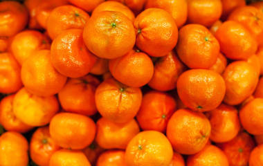 橘色背景。有機成熟的官僚在市場上。收獲的概念。堆 clementines