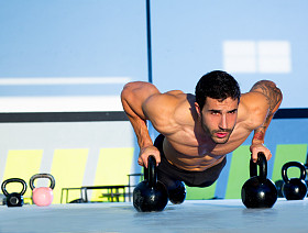 健身房男子俯卧撑强度伏地挺身与 kettlebell