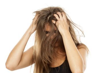 美麗的年輕女人在她的頭皮上發(fā)癢