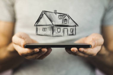 手与电话和图画房子