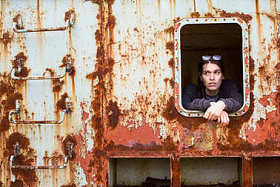 一个年轻的女人在一个废弃的铁生锈的对象的窗口的肖像