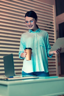 拿着咖啡和笔记本电脑看书的漂亮女人