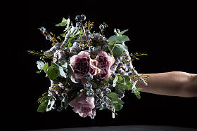 在木制背景的玻璃花瓶中的原始和不寻常的花束