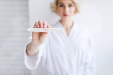 抱正妊娠試驗(yàn)的年輕女子的近距離