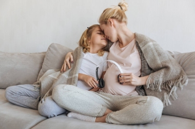 懷孕的母親和女兒給未出世的孩子聽音樂