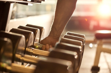 男子手的特写抓住哑铃的重量图片