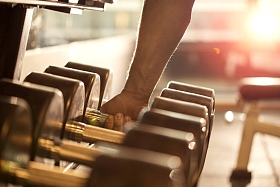 男子手的特写抓住哑铃的重量图片