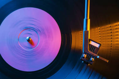 電影復(fù)古風(fēng)格的記錄播放機(jī)紡黑乙烯唱片。Cinemagraph側(cè)面視圖。美麗的霓虹夜的顏色