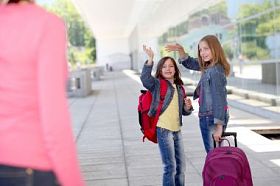 女学生在他们的妈妈挥手道别图片