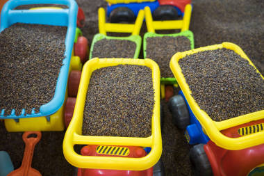 孩子们和用决明子做“沙”的人一起做五颜六色的玩具