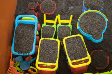 孩子们和用决明子做“沙”的人一起做五颜六色的玩具