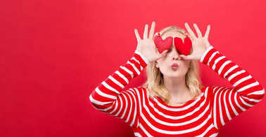 快樂的年輕女子捧著心靠墊圖片