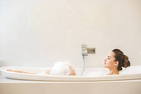 年轻美丽的女人在家里洗澡的侧视图