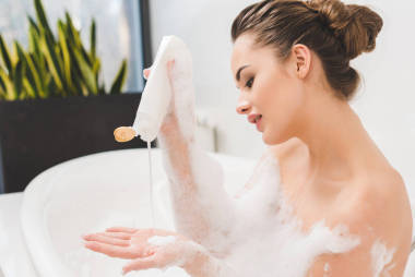 年輕女子沐浴用凝膠和泡沫的側(cè)面圖 