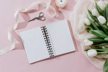 白色郁金香, 絲帶和記事本在粉紅色, 國際婦女節(jié)背景的頂部視圖