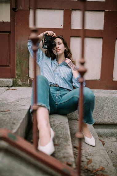 年轻的妇女与即时照相照相机。妇女与古董相片照相机