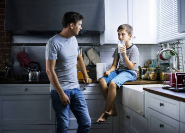 父親和兒子在廚房, 男孩拿著玻璃牛奶