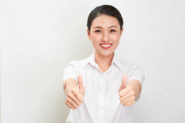 年輕的亞洲婦女顯示拇指手勢使用雙手