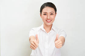 年轻的亚洲妇女显示拇指手势使用双手