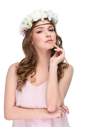 在白色的花卉花圈的卷发年轻女子