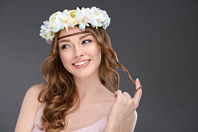 在灰色的花花环上嬉戏的年轻女子卷曲的头发