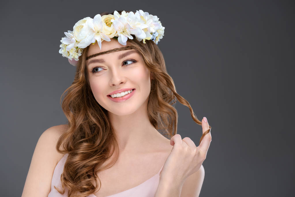 在灰色的花花环上嬉戏的年轻女子卷曲的头发