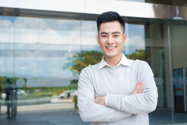 英俊自信的亞洲男子的肖像站在建筑外