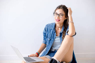 微笑美麗的女孩在眼鏡與筆記本電腦工作室拍攝